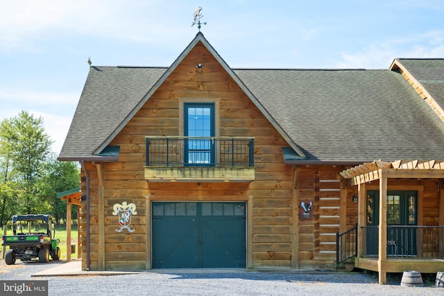 cabin featuring a pergola, a garage, and a balcony