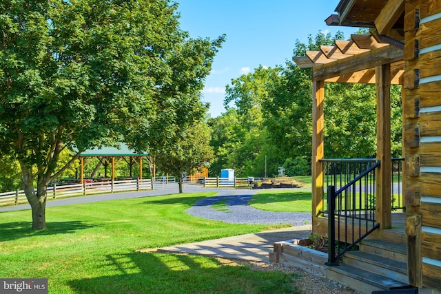 view of property's community featuring a pergola and a lawn