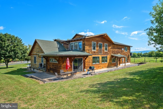 rear view of property featuring a lawn and a patio