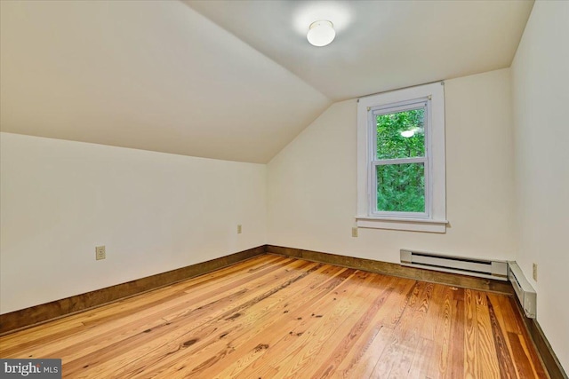 additional living space with hardwood / wood-style floors and vaulted ceiling