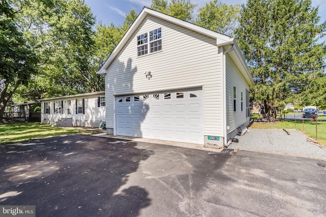 view of side of property featuring a lawn and a garage