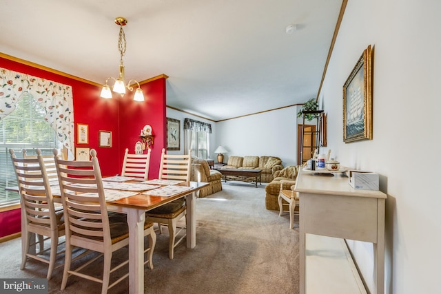 carpeted dining space with crown molding and an inviting chandelier