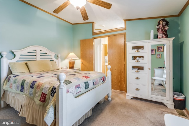 carpeted bedroom featuring ceiling fan and ornamental molding