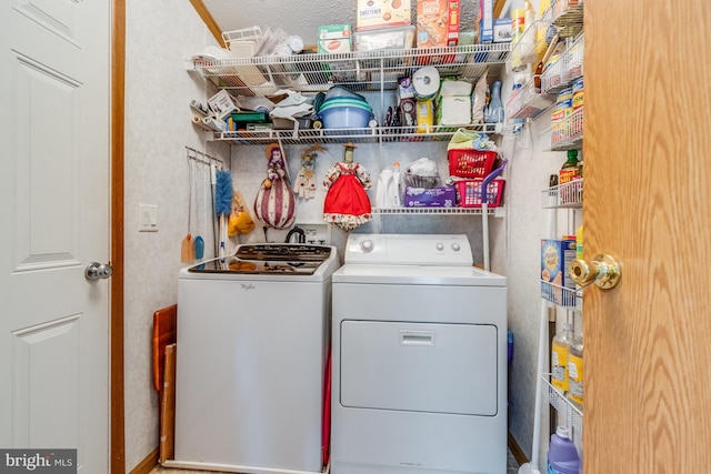 laundry room featuring washer and clothes dryer and a textured ceiling