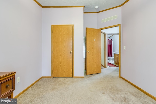 unfurnished bedroom with a towering ceiling, crown molding, a textured ceiling, and light carpet