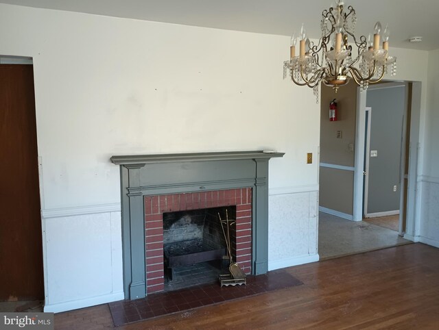 room details featuring a brick fireplace, hardwood / wood-style flooring, and a chandelier