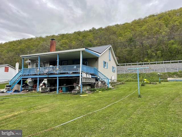 back of property featuring a lawn and a deck