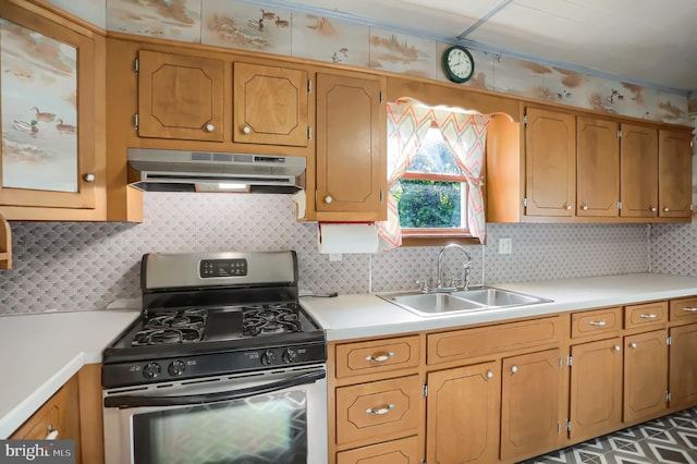 kitchen featuring sink, backsplash, and stainless steel gas stove