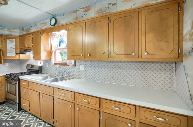 kitchen featuring gas range, sink, and tasteful backsplash