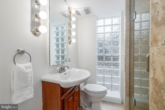 bathroom featuring vanity, tile patterned flooring, toilet, and walk in shower