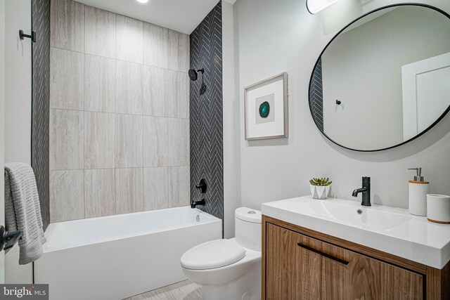 full bathroom featuring tiled shower / bath, vanity, and toilet