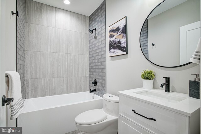 full bathroom with toilet, tiled shower / bath combo, and vanity