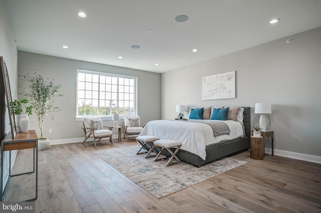 bedroom featuring baseboards, wood finished floors, and recessed lighting