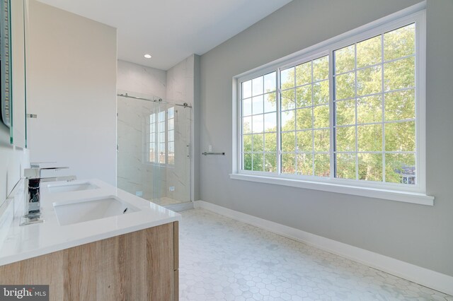 bathroom with a shower with shower door, plenty of natural light, and tile patterned flooring