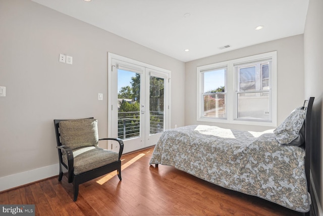 bedroom featuring access to exterior, dark hardwood / wood-style floors, and french doors