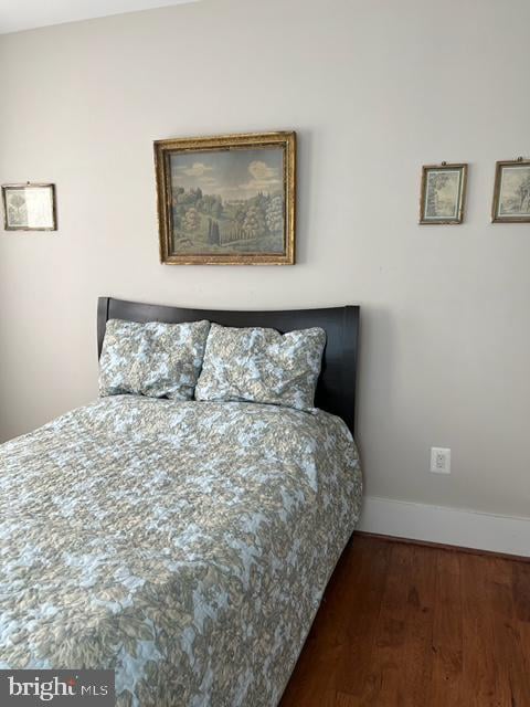 bedroom with dark hardwood / wood-style flooring