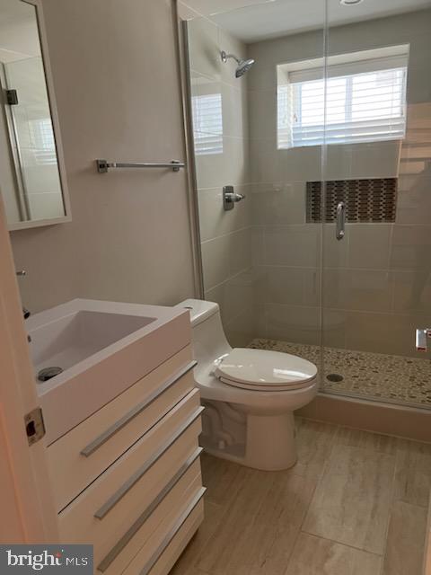 bathroom with vanity, toilet, an enclosed shower, and hardwood / wood-style flooring