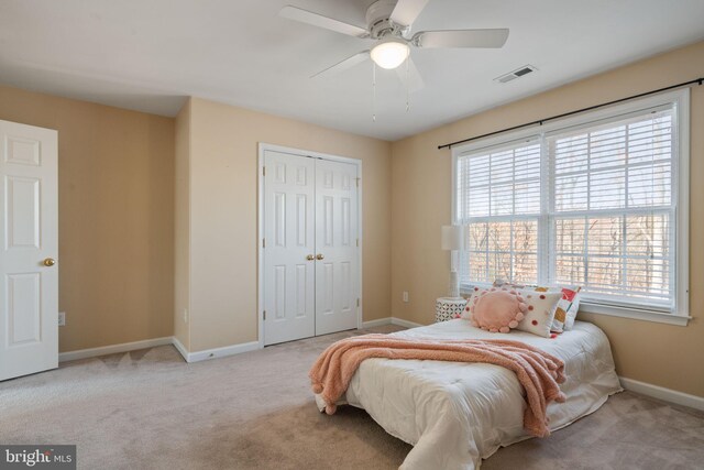 carpeted bedroom with ceiling fan and a closet