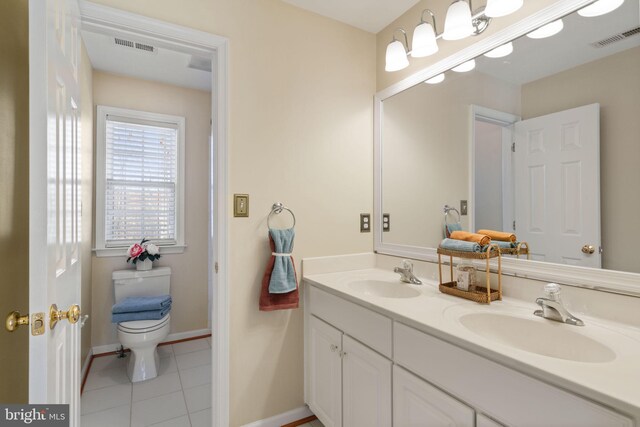 bathroom with toilet, vanity, and tile patterned floors