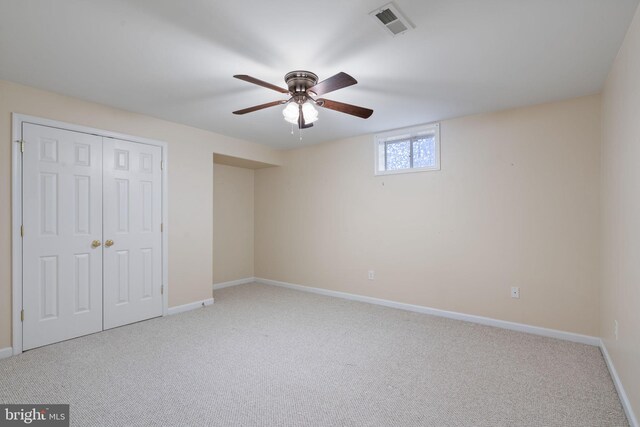 bedroom with ceiling fan, light carpet, and a closet