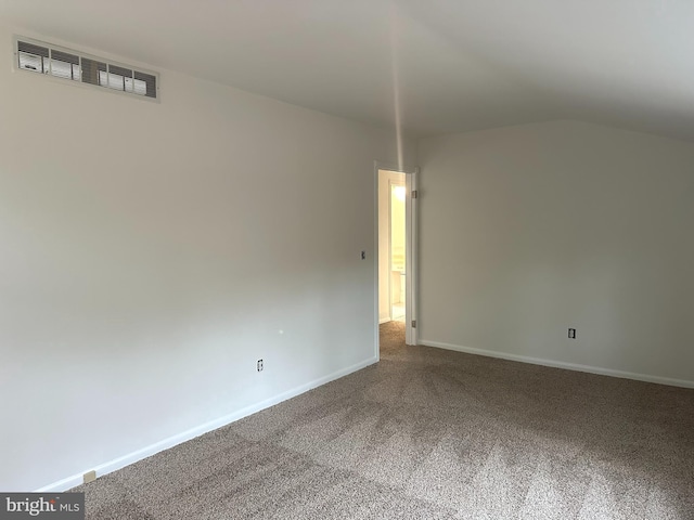 unfurnished room featuring lofted ceiling and carpet floors