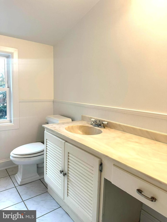 bathroom with toilet, tile patterned flooring, and vanity