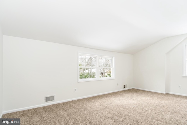 spare room with carpet floors and lofted ceiling