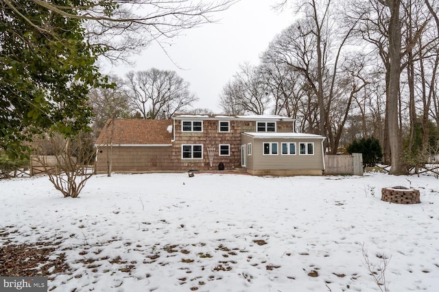 snow covered property with an outdoor fire pit