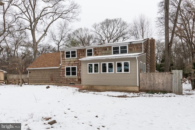 view of snow covered back of property