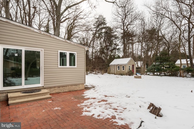 yard covered in snow featuring a storage shed