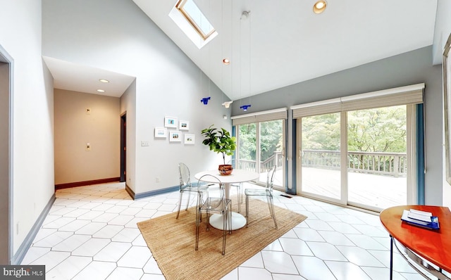 dining space with a skylight, high vaulted ceiling, and light tile patterned flooring