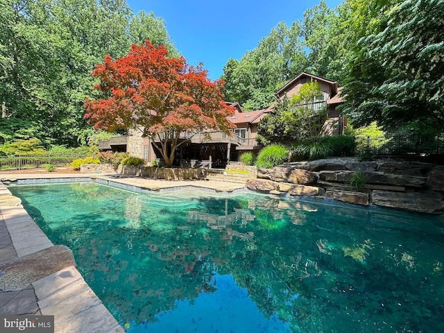 outdoor pool featuring fence