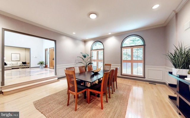 dining area featuring crown molding and light hardwood / wood-style flooring