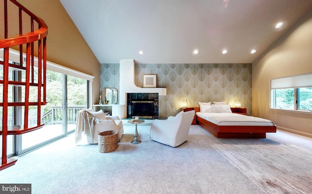 bedroom featuring light carpet, access to exterior, a fireplace, and high vaulted ceiling