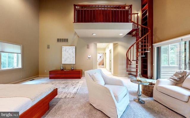 carpeted living room with a high ceiling