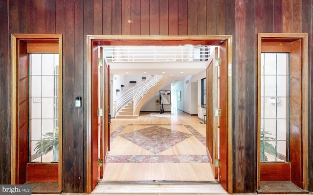 entryway featuring stairway and wooden walls