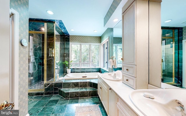 bathroom featuring vanity, a shower stall, a garden tub, and recessed lighting