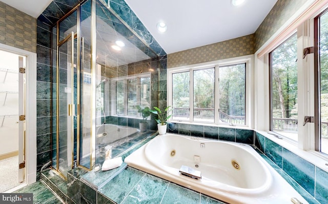 bathroom with plenty of natural light, independent shower and bath, and tile walls