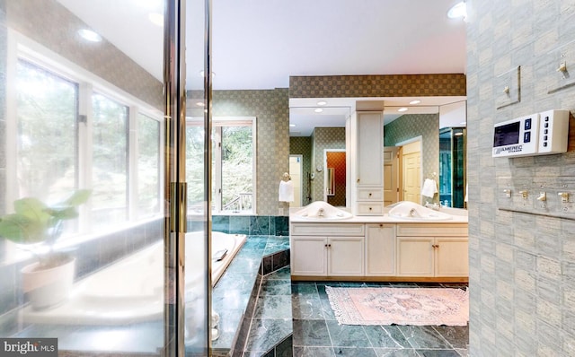 bathroom featuring vanity and tiled bath