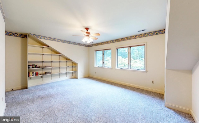 carpeted empty room featuring baseboards, visible vents, and ceiling fan