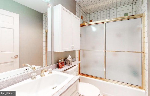 full bathroom with vanity, enclosed tub / shower combo, and toilet