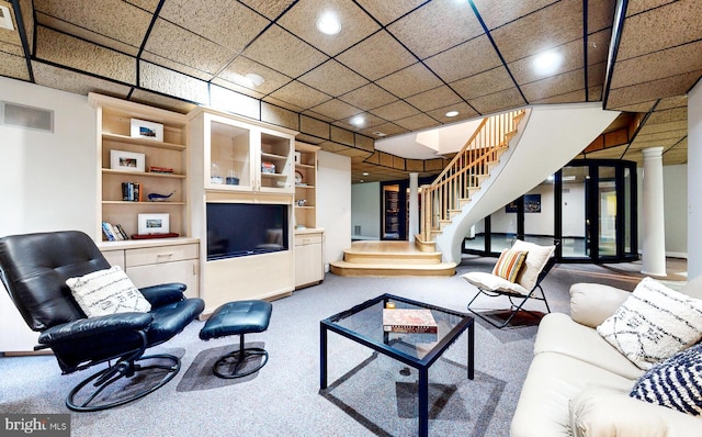 carpeted living room with decorative columns and built in shelves