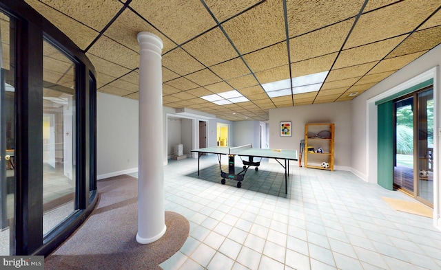 game room with tile patterned flooring, a paneled ceiling, and baseboards