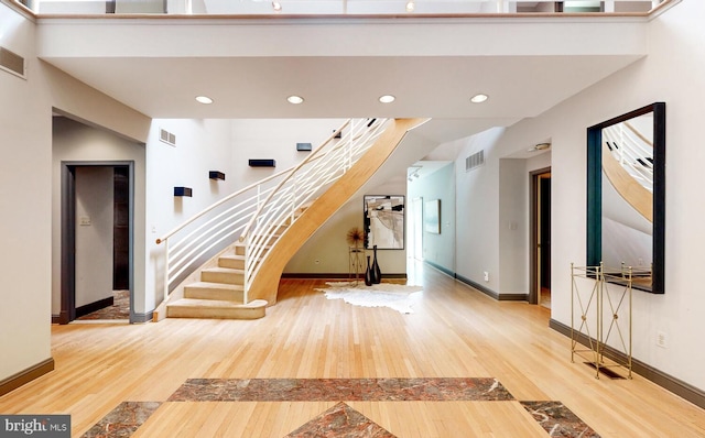 interior space featuring visible vents, stairway, baseboards, and wood finished floors