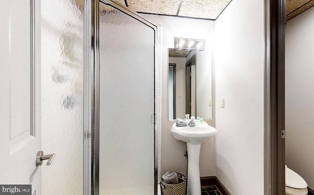 bathroom with toilet, an enclosed shower, and sink