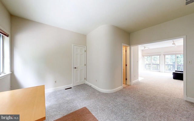 spare room with carpet, visible vents, and baseboards