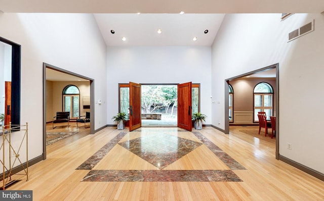 entryway featuring light hardwood / wood-style floors and a high ceiling