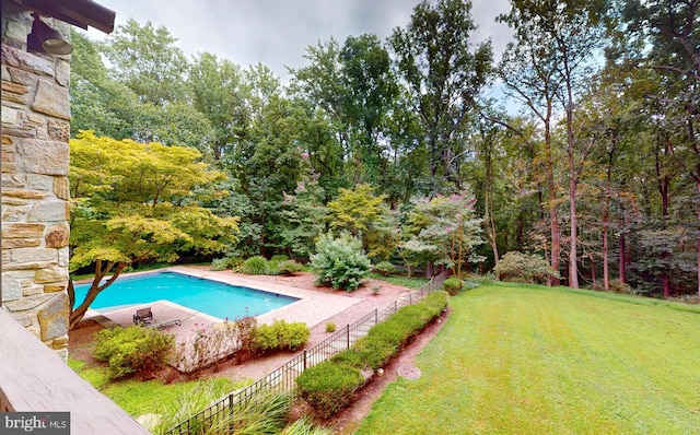 view of swimming pool featuring a yard