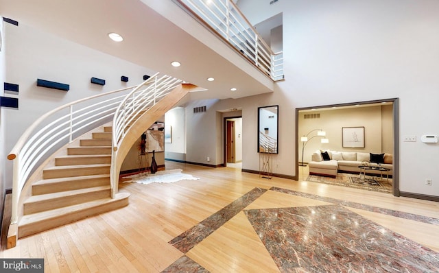 foyer entrance featuring a high ceiling and hardwood / wood-style floors