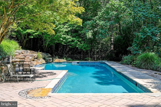 view of swimming pool featuring a patio area, a fenced in pool, and fence